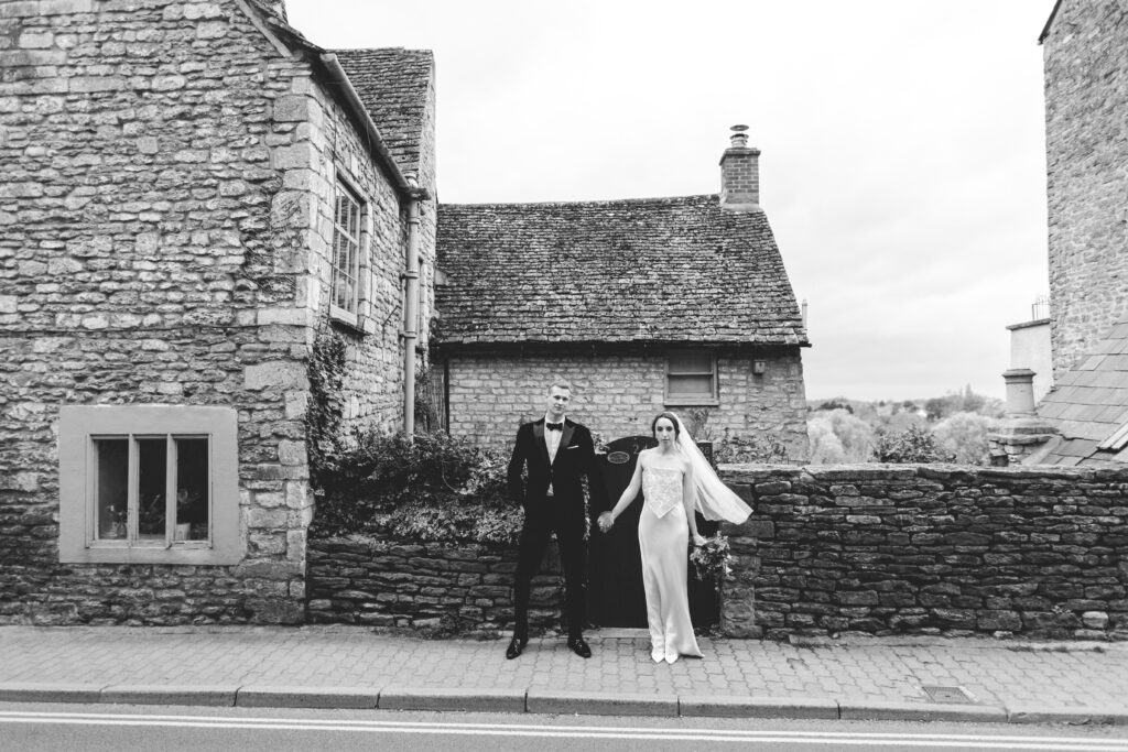 Black and white image of bride and groom on Malmesbury High Street